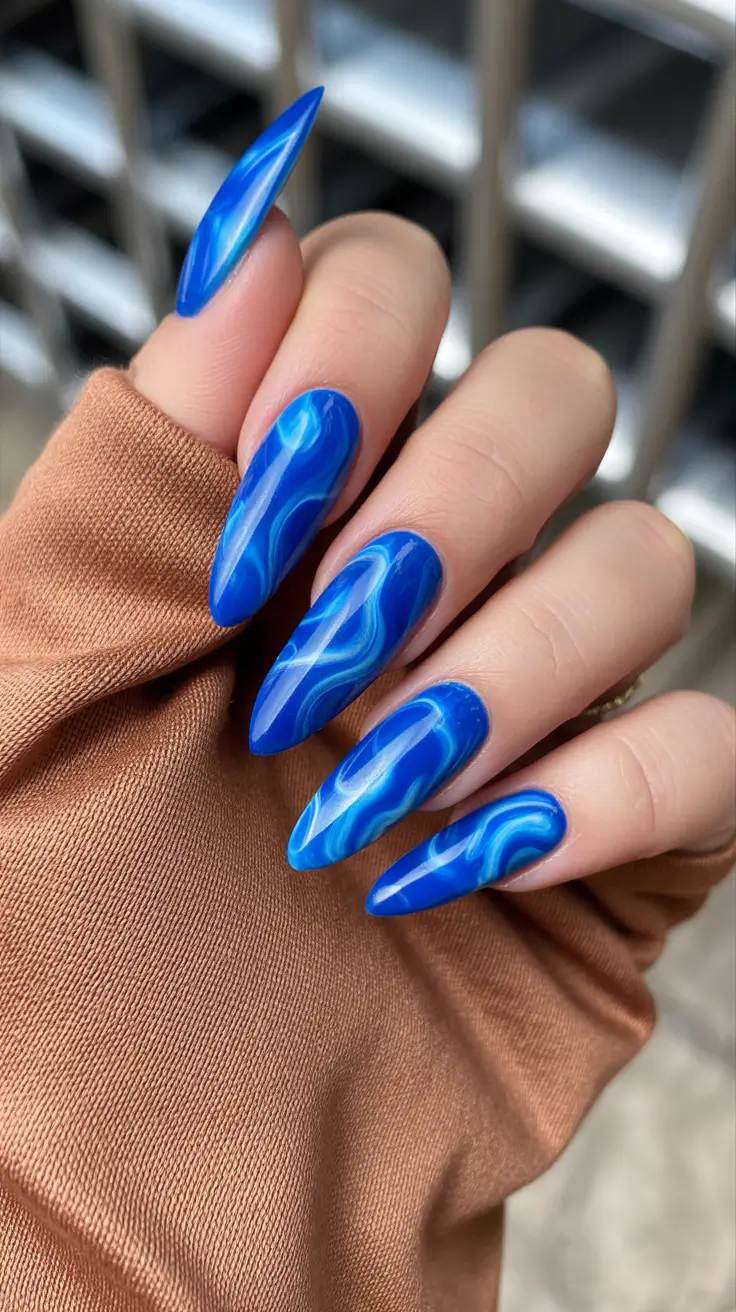 best classy spring nails 2026 Electric Marble Blue on Sculpted Almond