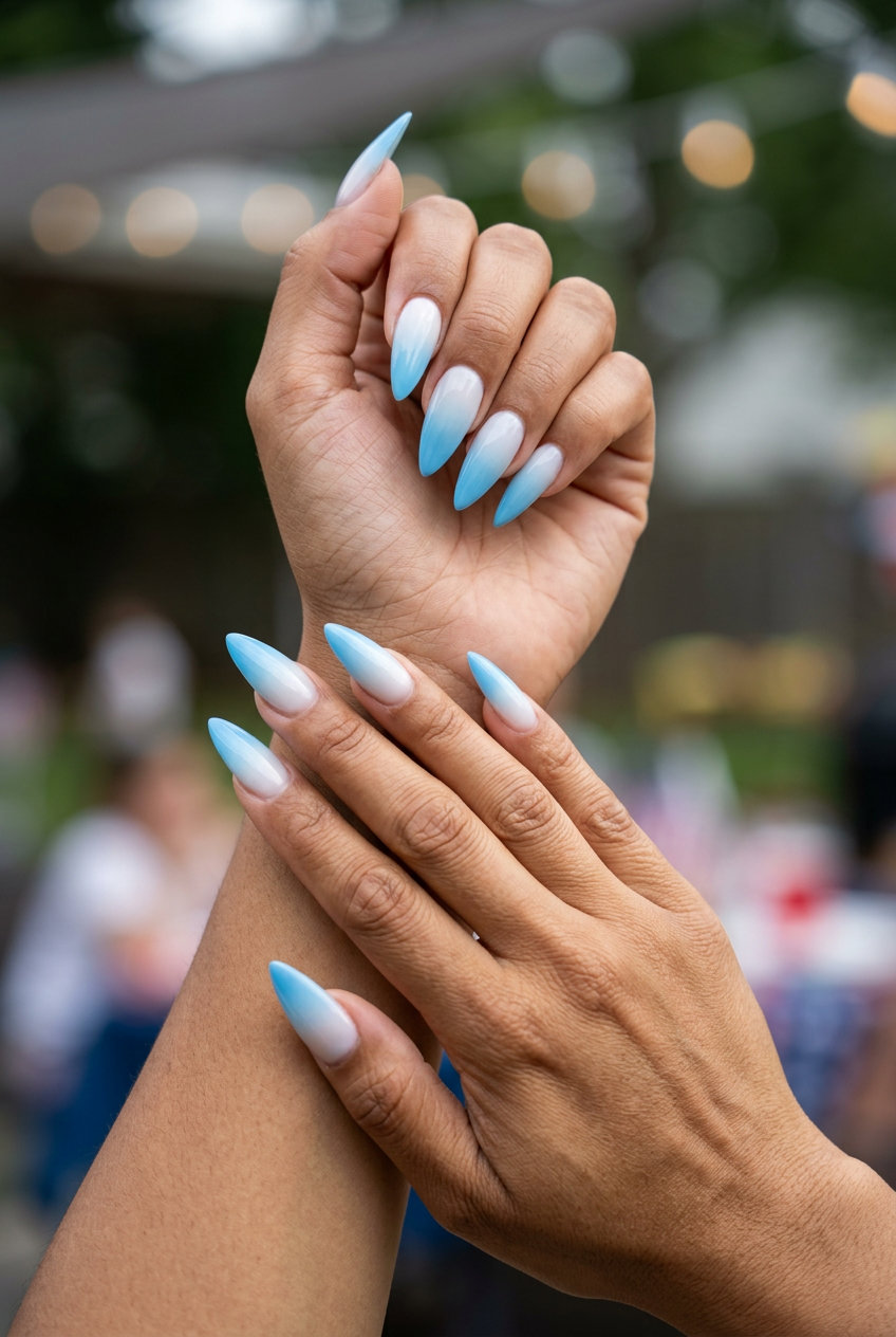 Ethereal 4th of July nails 2026: Extra-long stiletto nails with milky white to bright blue ombre.