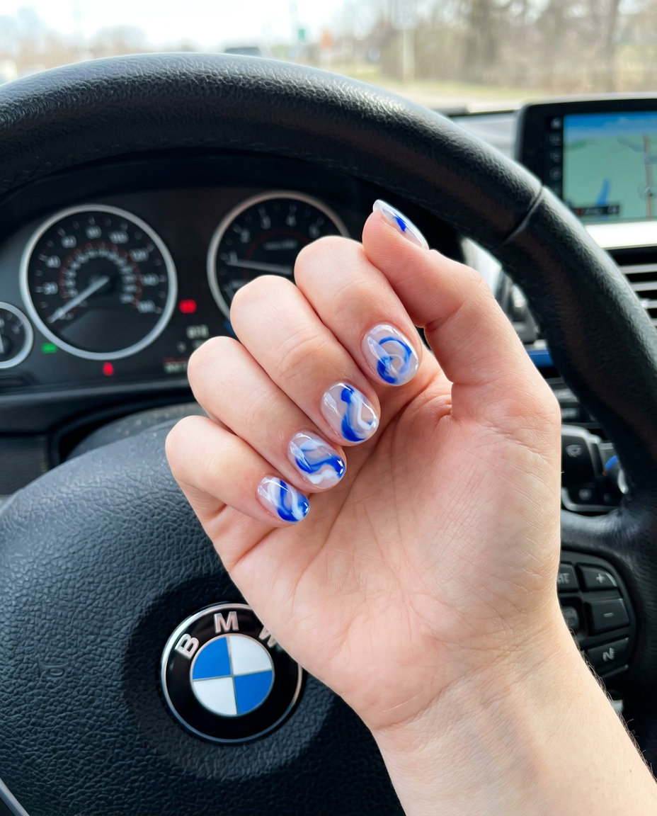 Artistic 4th of July nails 2026: Clear glass-like nails with cobalt blue and milky white swirls.