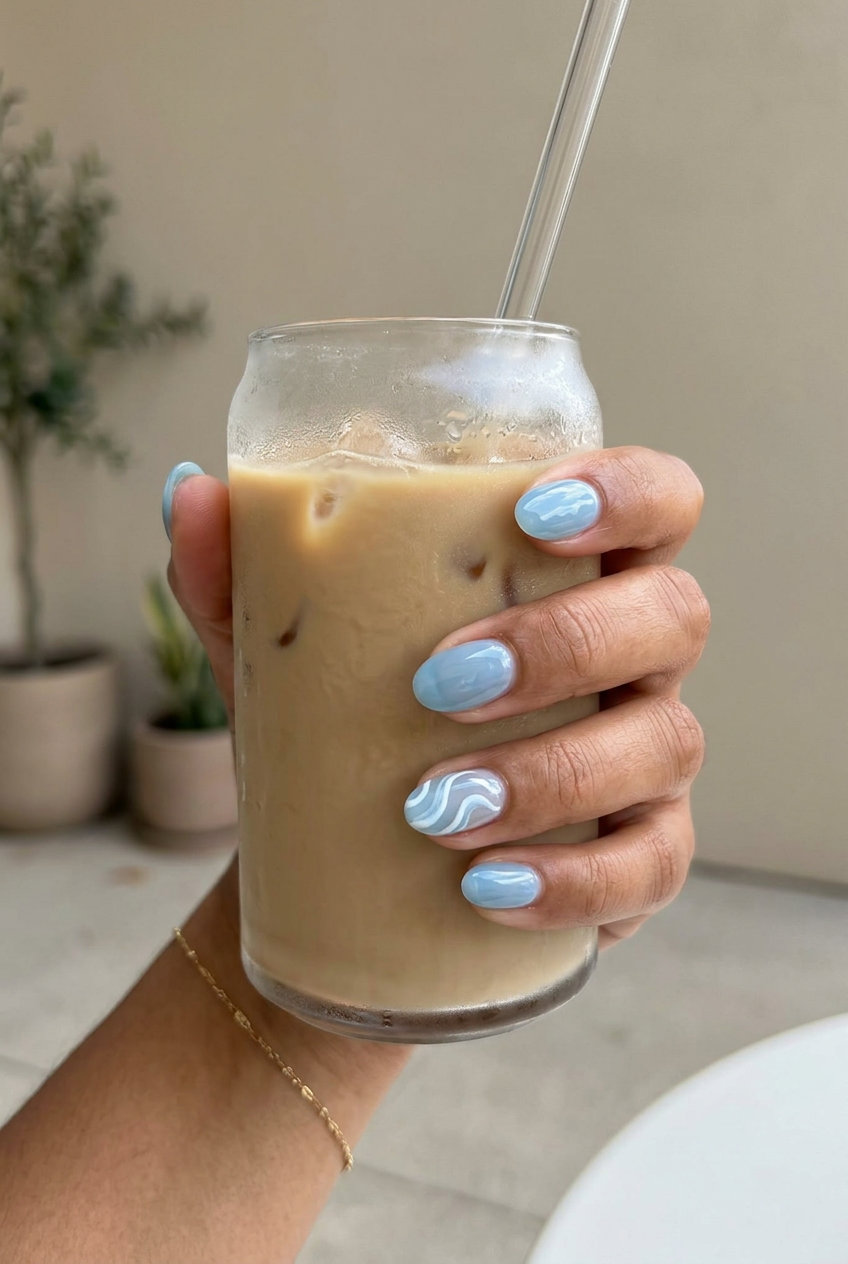 Bohemian short oval summer nails 2026 with ocean wave blue and white swirls for vacation.