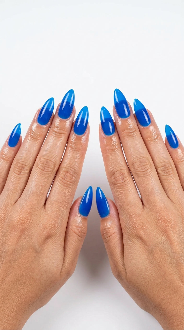 Edgy electric blue jelly stiletto summer nails 2026 for vacations. Vibrant translucent color with high shine.