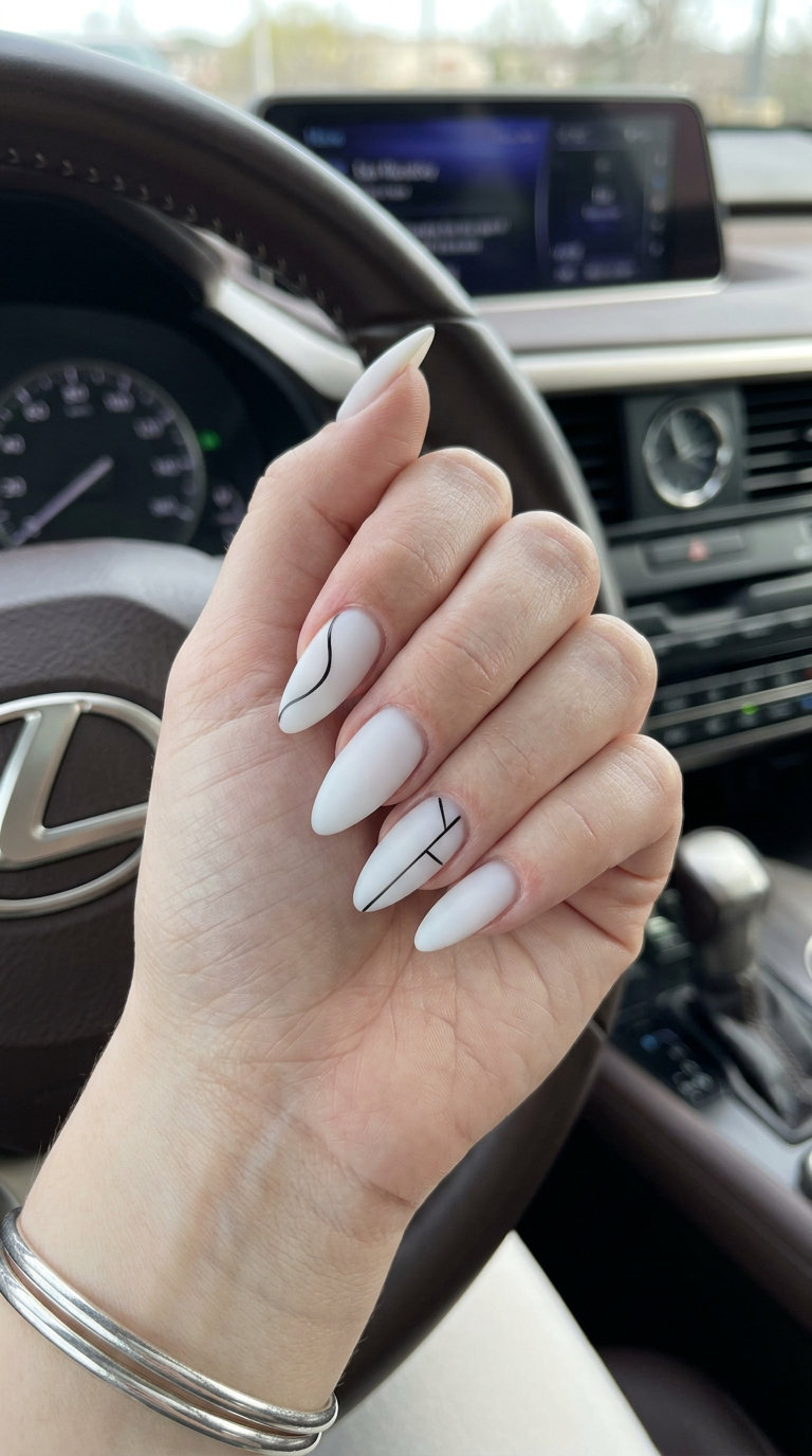 Minimalist black line stiletto nails on a milky white matte base. Stiletto summer nails 2026.