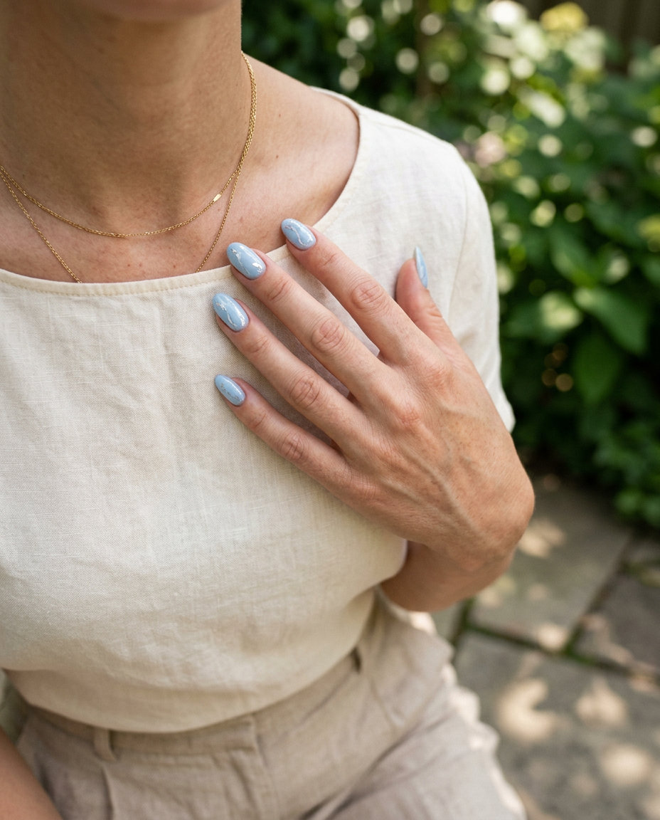 Summer classy nails 2026: Pale blue marble with silver foil on short square nails for wedding guest.