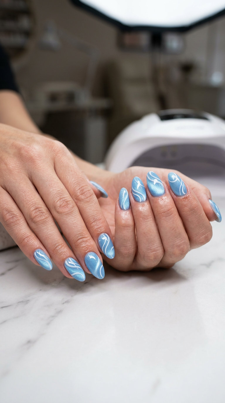 Sky Blue Cat-Eye Nails 2026: Dreamy & Mysterious Dreamy sky blue cat-eye nails with white swirls, ideal for summer colorful nails designs 2026.