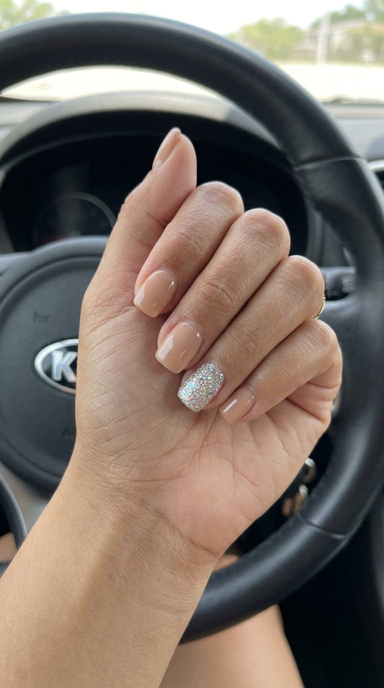 Nude nails with glitter accent for parties and cocktail hour, a glamorous trending summer nails 2026 style.
