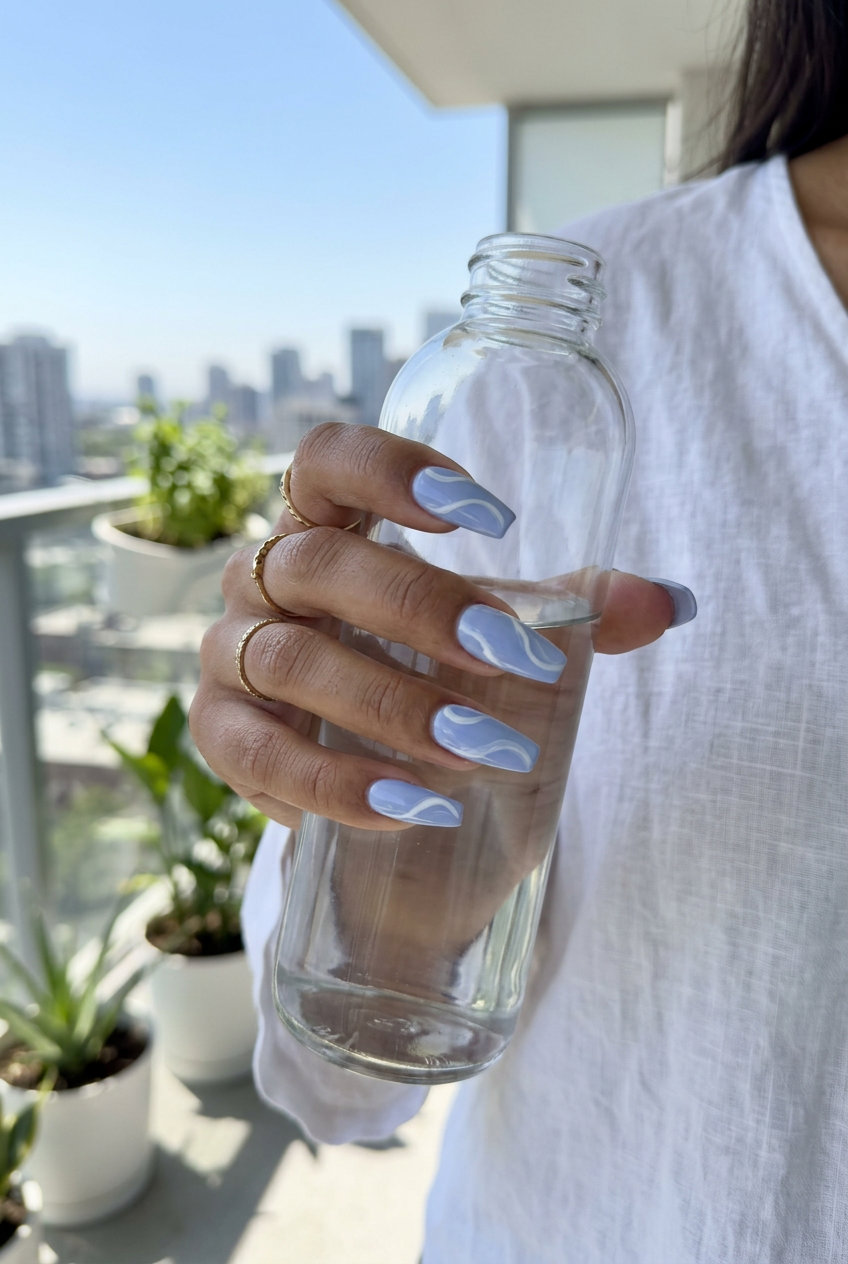 Trending summer nails 2026: Dreamy periwinkle blue with white swirls on long coffin nails for formal events.