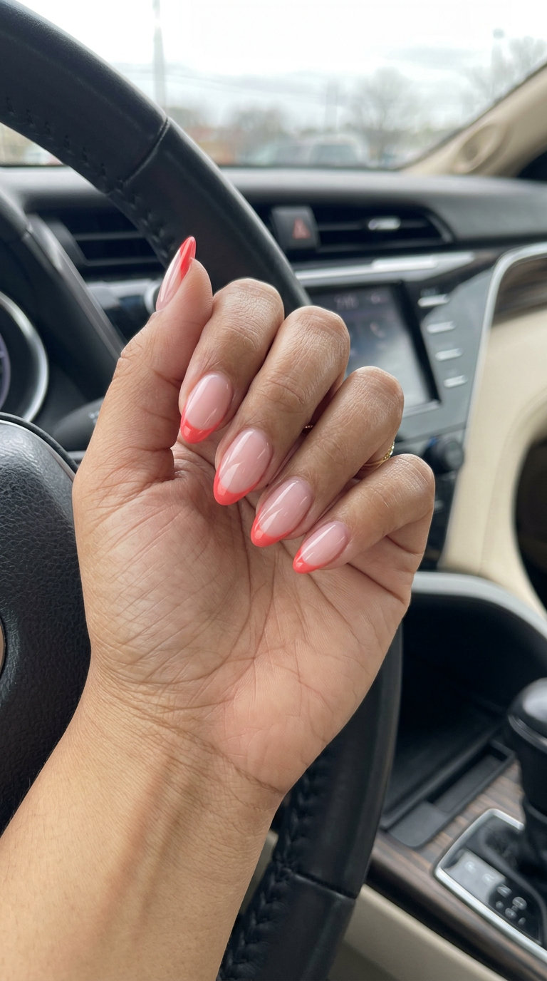 Tropical nail designs 2026: Minimalist vivid coral micro French tips on milky pink nails.
