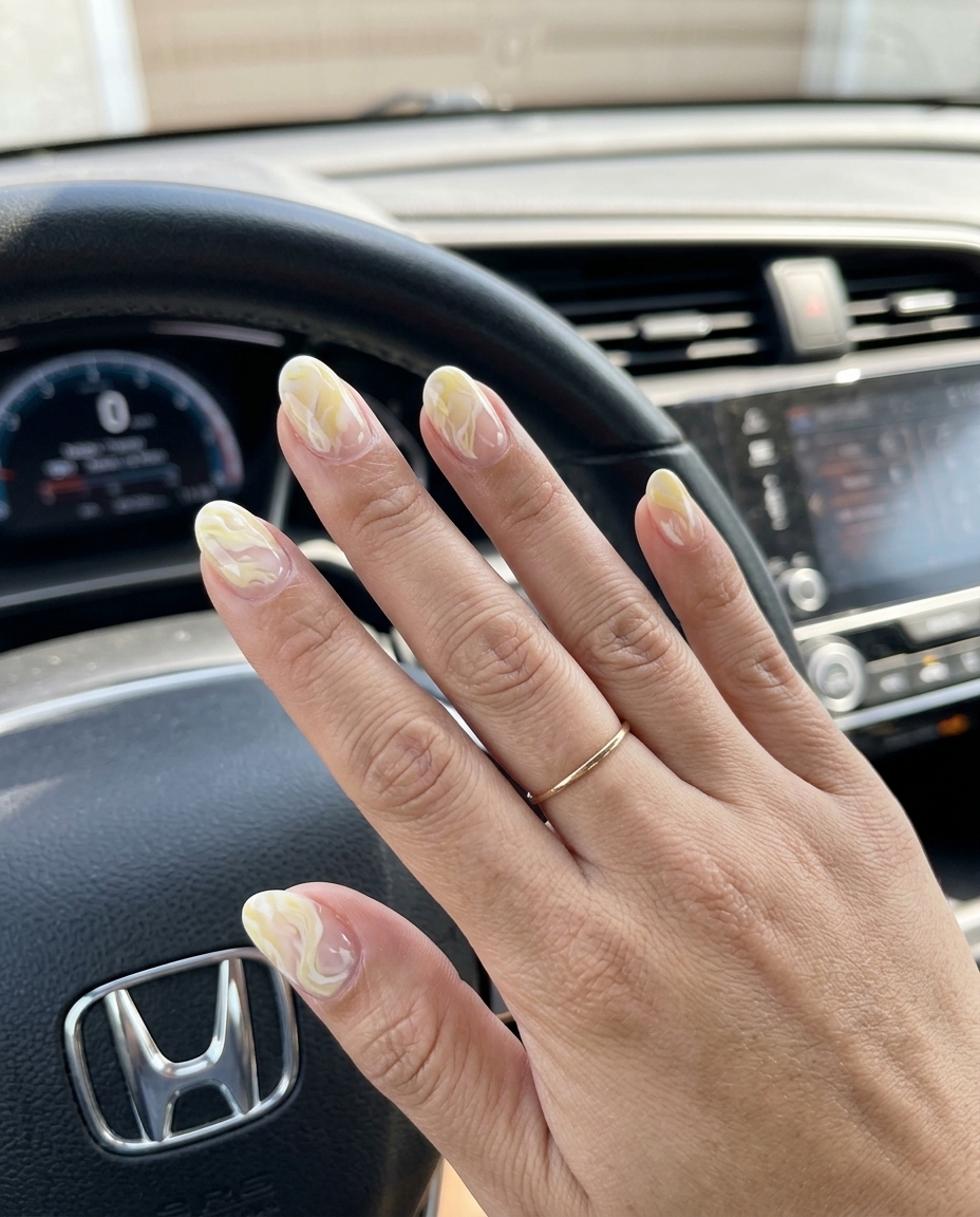 Yellow Summer Nails 2026: Artistic Marble Chic Sophisticated pale yellow and white marble nails with negative space. Yellow summer nails 2026 for events.